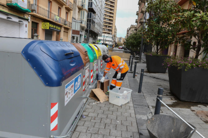 Un treballador d'FCC recollint cartons i elements que la gent deixa fora dels contenidors.