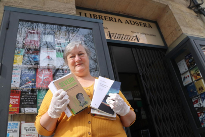 Gertri Adserà, responsable de la librería Adserà de Tarragona, ante el establecimiento con los libros que recomienda.