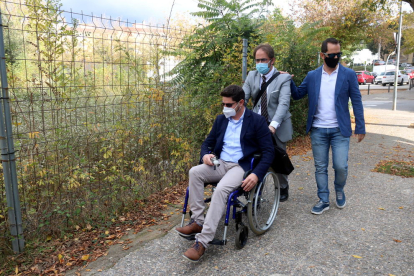 El Isaac Padrós, en silla de ruedas, en compañía de su abogado Joan Benítez.