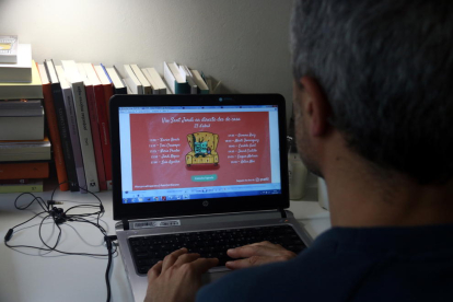 Una persona observa las propuestas online de los autores del Grupo 62 por Sant Jordi.