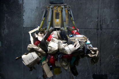 El gancho de una grúa elevando varias bolsas de residuos sanitarios para introducirlas al horno de la incineradora Sirusa de Tarragona.