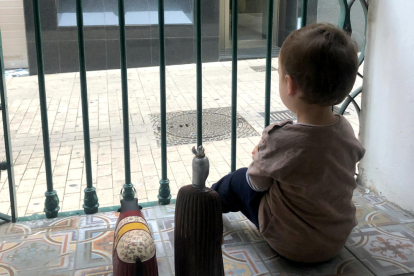 Un nen mira des del balcó de casa, durant el confinament.