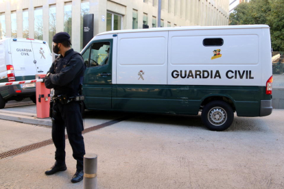 Un Mosso d'Esquadra custodiant l'entrada d'una de les furgonetes de la Guàrdia Civil