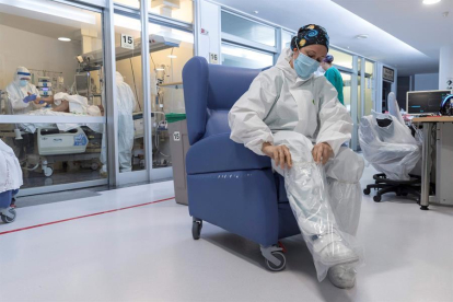 Una enfermera de la Unidad de Cuidados intensivos (UCI), se coloca las protecciones necesarias antes de entrar en un box.