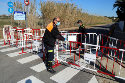 Efectivos de Protección Civil y de la Policía Local del Vendrell acabando de colocar las vallas en un acceso secundario, en torno a las Madrigueres.