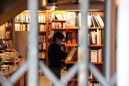 Una llibreria amb la persiana abaixada, però amb els seus empleats treballant per Sant Jordi.