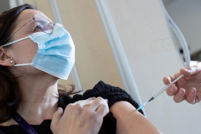 Una infermera de l'Hospital Sant Pau de Barcelona injecta la vacuna de covid-19 a una companya.