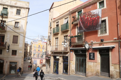 Una de las lonas con imágenes de los misterios de la Semana Santa de Tarragona en una de las calles de la Parte Alta.