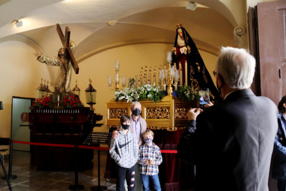 Un grup de persones fent-se una fotografia davant d'alguns misteris de Setmana Santa a l'església de Santa Maria de Natzaret.