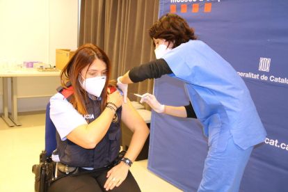 Una agente de los Mossos d'Esquadra recibiendo una dosis de la vacuna de AstraZeneca en la comisaría de Tortosa.