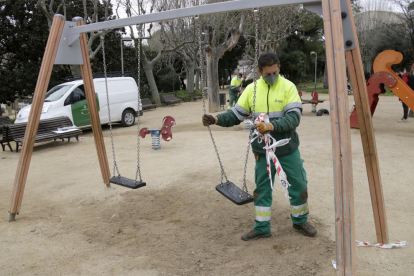 Operarios municipales del Ayuntamiento de Mataró desprecintan un parque alumbre.