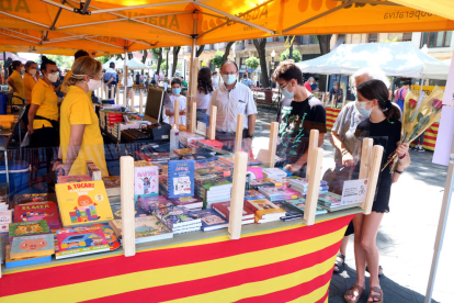 Una parada de llibres a la Rambla Nova de Tarragona amb diversos clients.