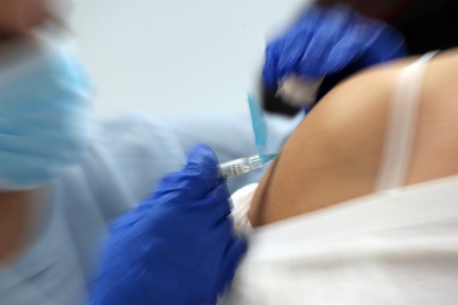 Una infermera posa una vacuna.