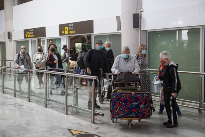 Varios turistas salen de la sala de recogida de equipajes a su llegada al aeropuerto César Manrique de Lanzarote.