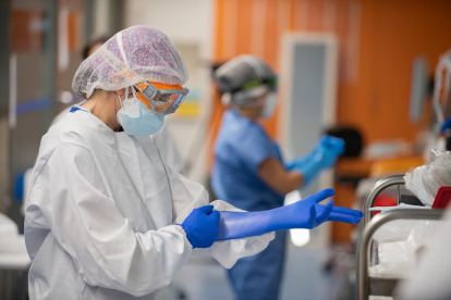 Una sanitàrai del Clínic posant-se guants de protecció a l'UCI amb malalts de covid