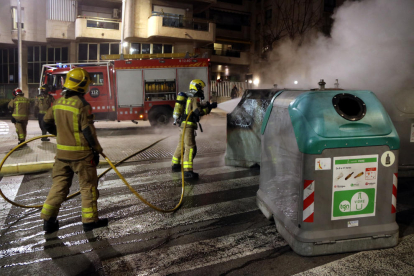 Una dotación de los Bombers apagando unos contenedores quemados en la avenida Catalunya de Tarragona.