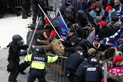 La policia intentant contenir els manifestants pro-Trump a l'exterior de l'edifici del Capitoli dels Estats Units.