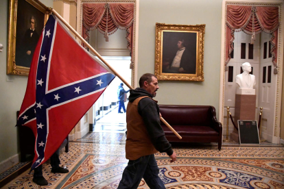 Un partidari del president Donald Trump porta la bandera confederada en l'assalt al Capitoli dels Estats Units, a Washington.