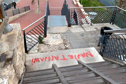 Una de las pintadas que hicieron los jóvenes en las escaleras de acceso al puente rojo de Tortosa desde el barrio de Ferreries.