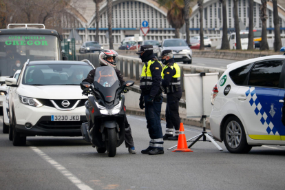 La Guàrdia Urbana de Barcelona parla amb un motorista durant un control a la Ronda Litoral arran del confinament municipal.