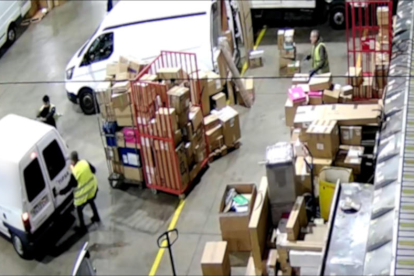 Dos hombres detenidos por los Mossos en una empresa de mensajería abriendo una furgoneta para cargar paquetes.