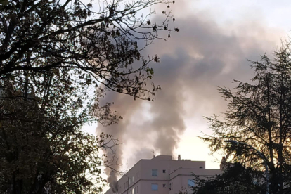El fum surt a l'exterior en l'incendi d'un habitatge en un edifici al carrer d'en Joan Reglà de Girona