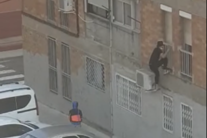 Imatge d'un dels joves grimpant per entrar a l'habitatge.