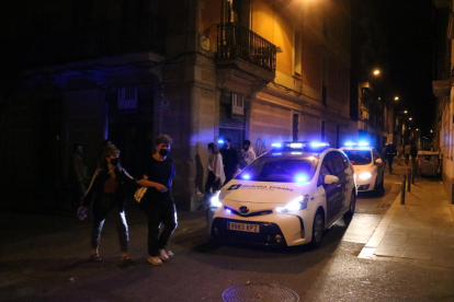 Dos coches de la Guardia Urbana patrullando por la calle.