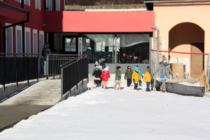 Alumnes d'una escola sortint al pati des del nou edifici.
