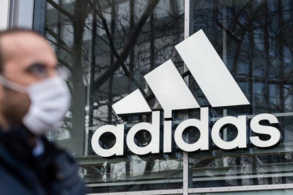 Logotip d'Adidas reflectit en una de les seves botigues.