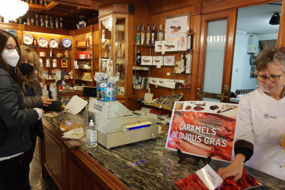 Unes dones comprant caramels de Dijous Gras a la pastisseria Santacana de Valls.