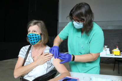 Una dona rebent una dosi de vacuna anticovid.