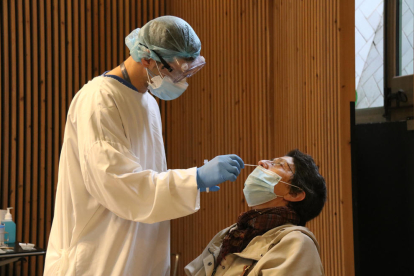 Una mujer haciéndose una prueba con test de antígenosen eal cribado en el recinto modernista del hospital Sant Pau de Barcelona.