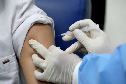Una enfermera poniendo una vacuna.