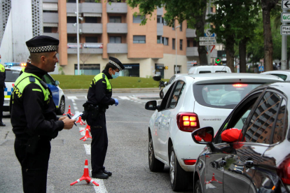 Dos agentes de la Guardia Urbana de Tarragona durante un control de tráfico en la calle Joan Miró, durante el periodo de confinamiento.