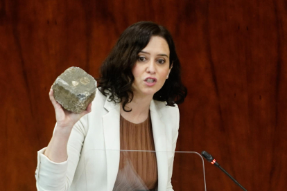 La presidenta de la Comunidad de Madrid, Isabel Díaz Ayuso, muestra a la Asamblea de Madrid un adoquín supuestamente utilizado a los disturbios