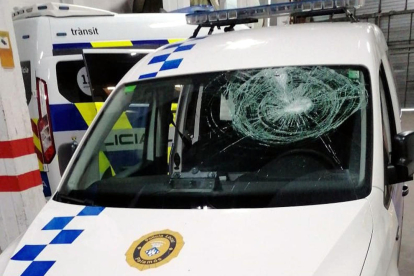 El cotxe patrulla de la Policia Local de Palamós amb el vidre del parabrisa trencat després de rebre l'impacte de dues ampolles.