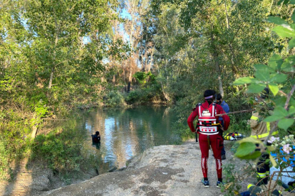 Submarinistas del cuerpo de los Bomberos rastreando el paraje donde ha desaparecido el chico que se ha ahogado mientras se bañaba en el río en Lleida