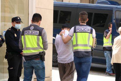 La policía se lleva a un detenido de una tienda de telefonía de la calle de la Rutlla de Girona.