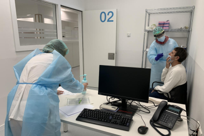 Dos personas haciendo una prueba PCR a un paciente en el espacio hospitalario polivalente del Arnau de Vilanova de Lleida.