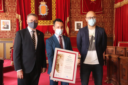 El presidente del Grupo de Ciudades Patrimonio de la Humanidad, Rafael Ruiz, muestra el Premio Tàrraco acompañado del alcalde de Tarragona, Pau Ricomà y del consejero|conseller de Patrimonio, Hermán Pinedo.