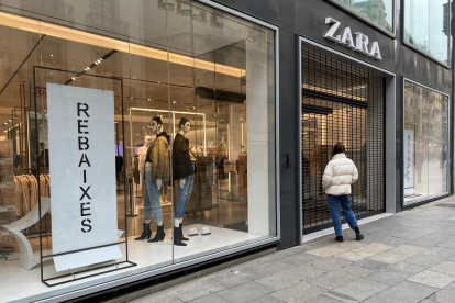 Una compradora davant d'una botiga Zara tancada al Portal de l'Àngel de Barcelona.