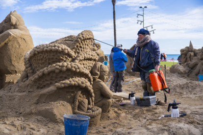 Uno de los artistas finalizando el belén|pesebre de arena.