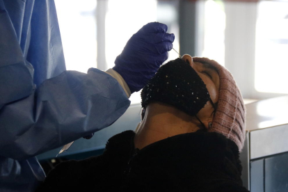 Una dona sotmetent-se a l'extracció de mostres per a un test d'antígens.