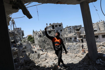 Plano general de un palestino caminando sobre escombros después del ataque aéreo y terrestre del ejército israelí en la Franja de Gaza.
