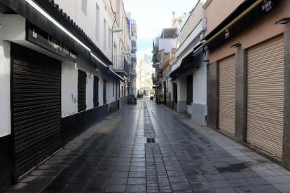Una calle del centro de Sitges con las persianas de los restaurantes i bares cerradas.