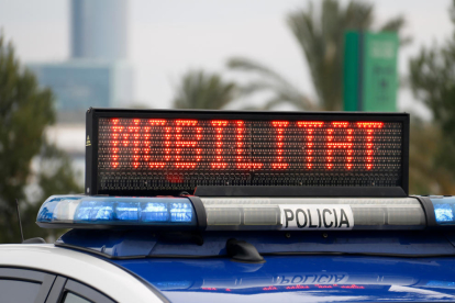 La señalización lumínica de un coche de la Guardia Urbana que indica que la movilidad está restringida.