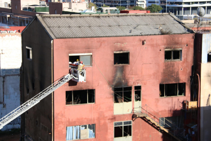 Plano generalde bomberos extrayendo a una de las víctimas mortales en el incendio de Badalona.