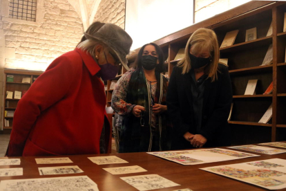 Pilarín Bayés i la consellera Àngels Ponsa, contemplen l'obra original de la primera a la Biblioteca de Catalunya.