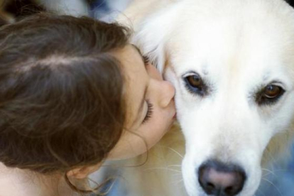 Imagen de archivo de una niña con su perro.